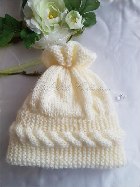 Baby Mütze, gestrickt mit Zopfmuster.