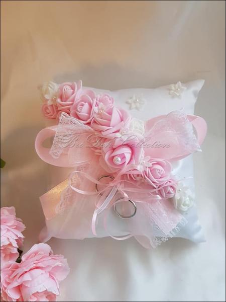 Weißes Ringkissen mit Blüten in rosa